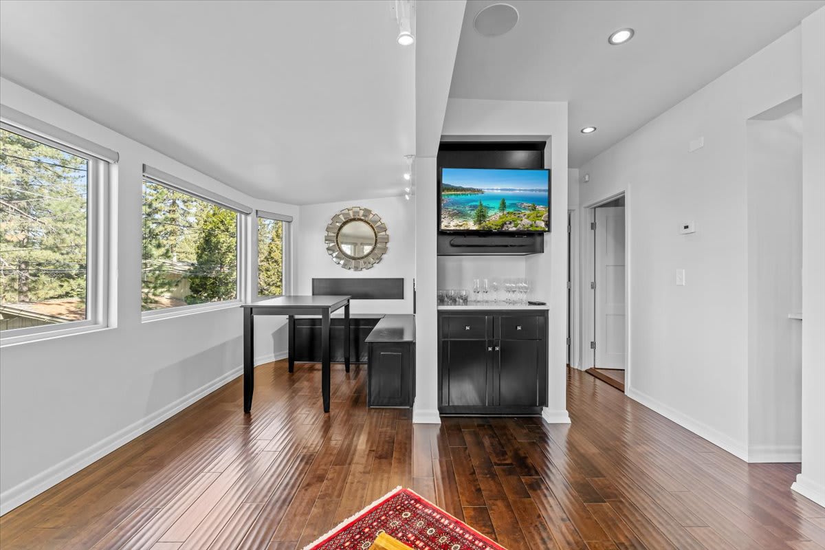 Spacious dining area in a Kings Beach vacation rental with large windows, wood floors, and modern furniture.