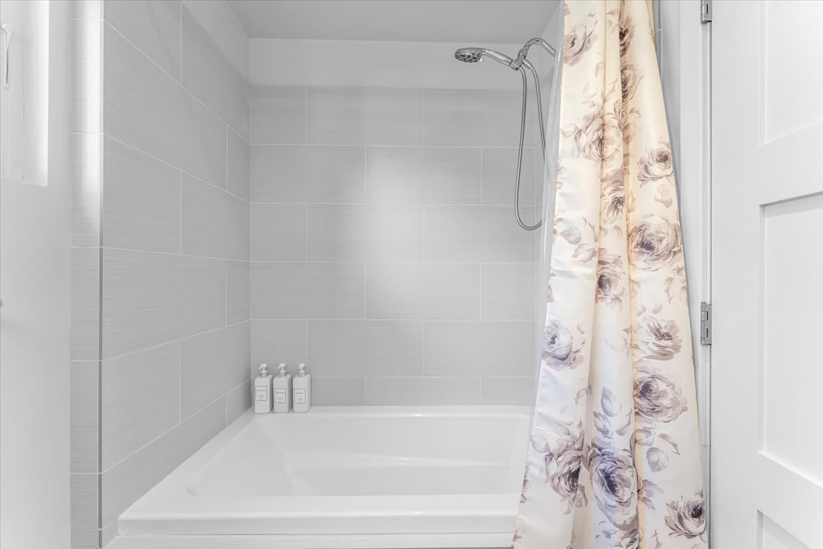 Bathtub with floral curtain in a Kings Beach vacation rental bathroom.