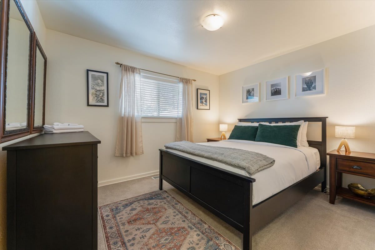 Cozy bedroom in a Truckee vacation rental, featuring a neatly made bed, warm lighting, and tasteful decor.