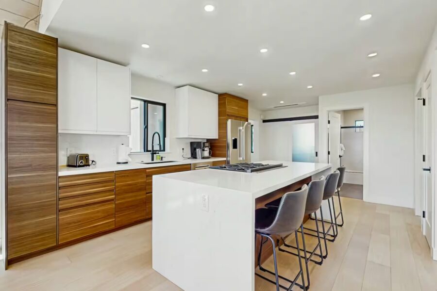 Modern kitchen in a Truckee vacation rental with wood cabinets, island, and barstools.