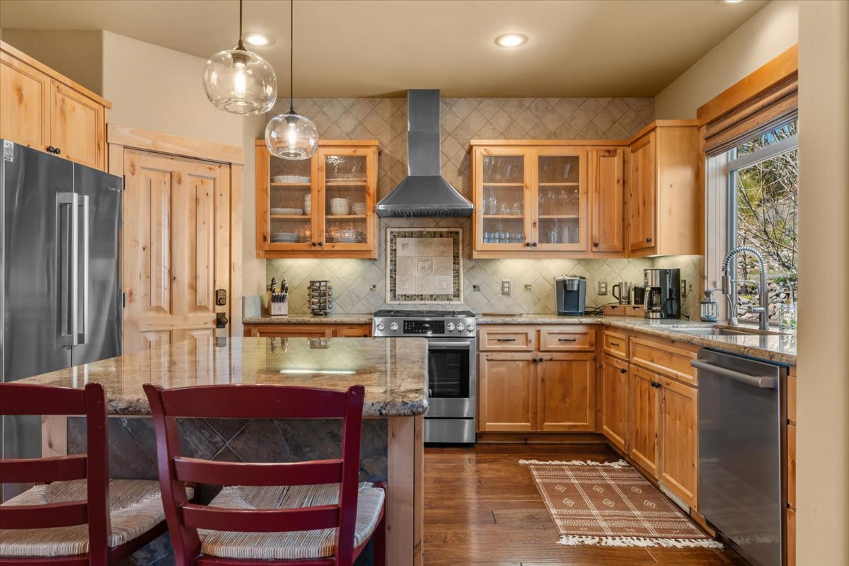 Rustic kitchen in a Truckee vacation rental featuring wooden cabinets, granite countertops, and modern appliances.