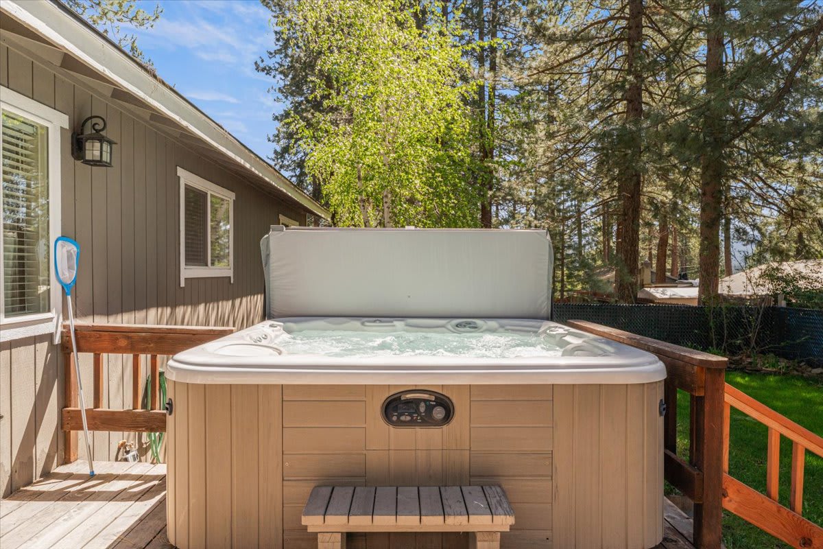 Hot tub on deck surrounded by trees at a vacation rental in Truckee, offering relaxation and nature views.