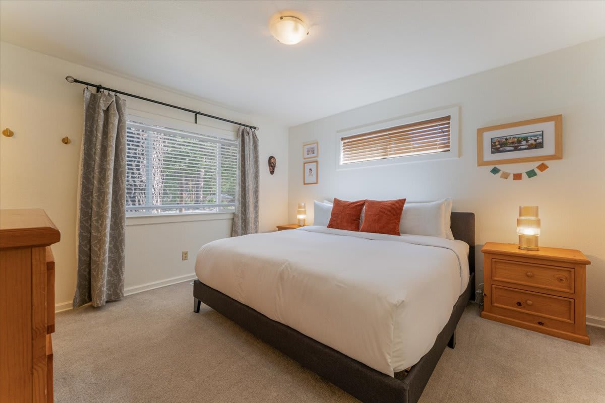 Cozy bedroom interior in a Truckee vacation rental with a plush bed, wooden nightstands, and soft lighting.