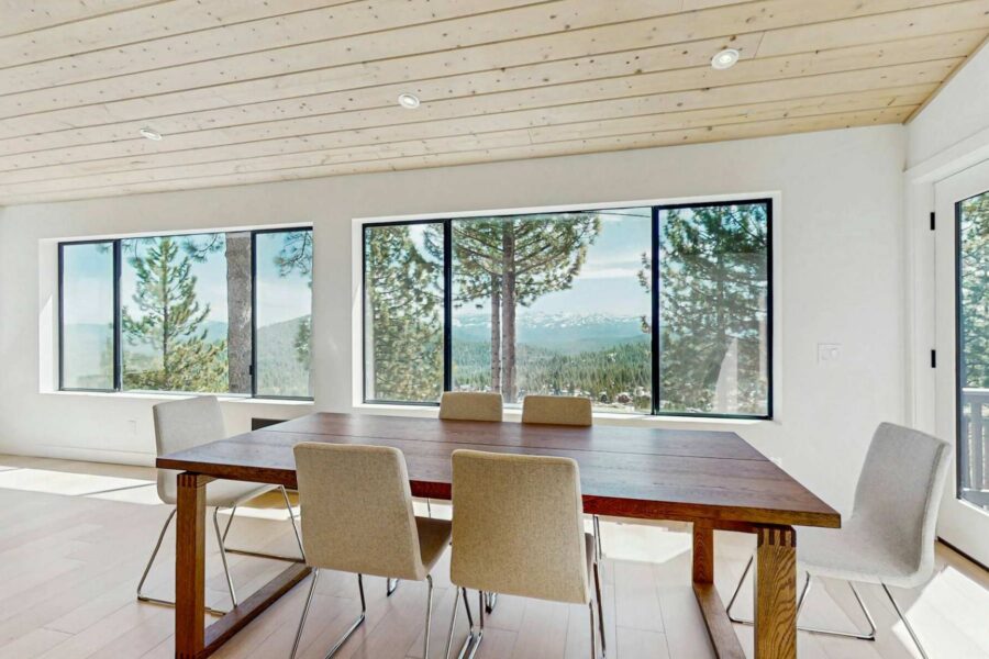 Dining area in Truckee vacation rental with large windows and forested mountain views.