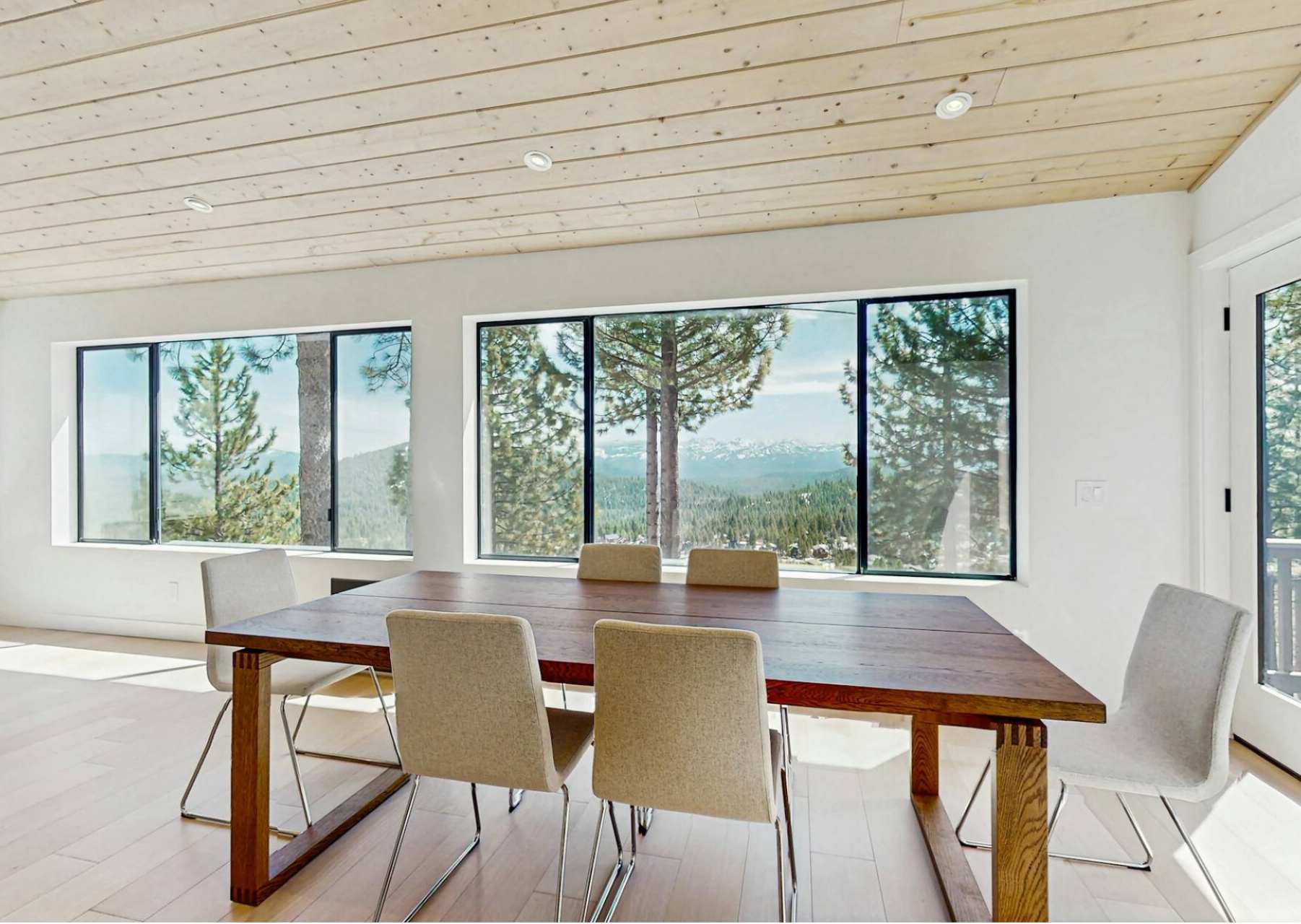 Dining area in Truckee vacation rental with large windows and forested mountain views.