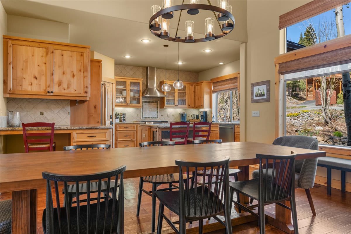 Spacious kitchen and dining area in a Truckee vacation rental, featuring wooden cabinets and large windows.