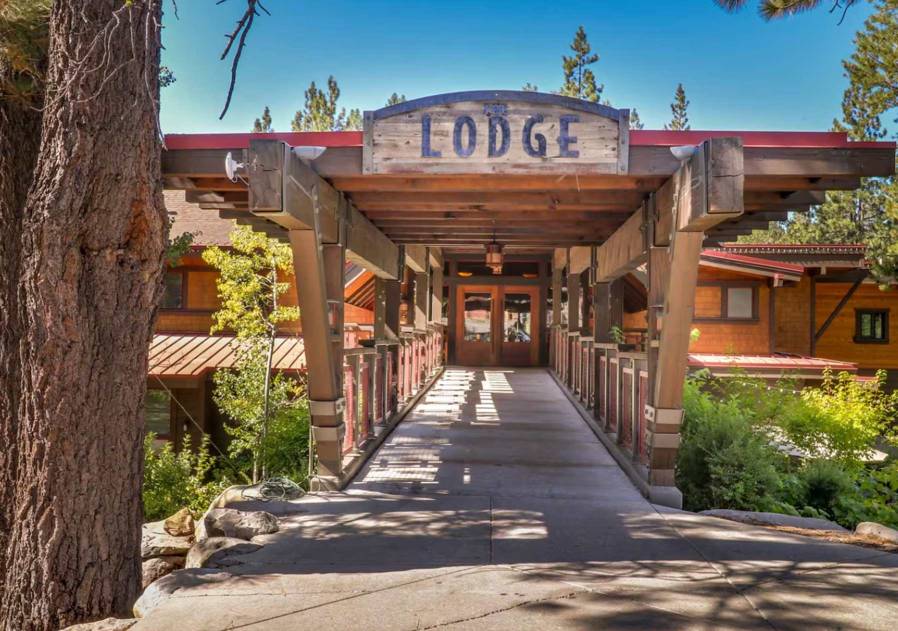 Wooden lodge entrance in Truckee, surrounded by trees, ideal for a vacation rental escape.