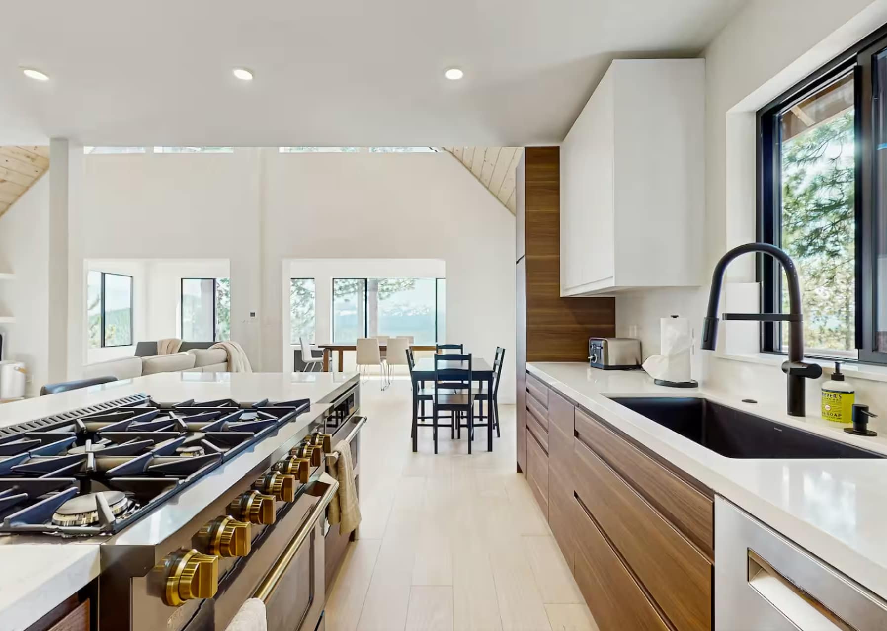 Modern kitchen in a Truckee vacation rental with a sleek stove, dining area, and large windows offering natural light.