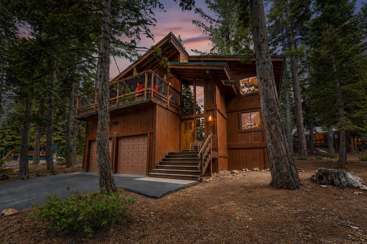 Rustic cabin vacation rental nestled among trees at sunset in Carnelian Bay.