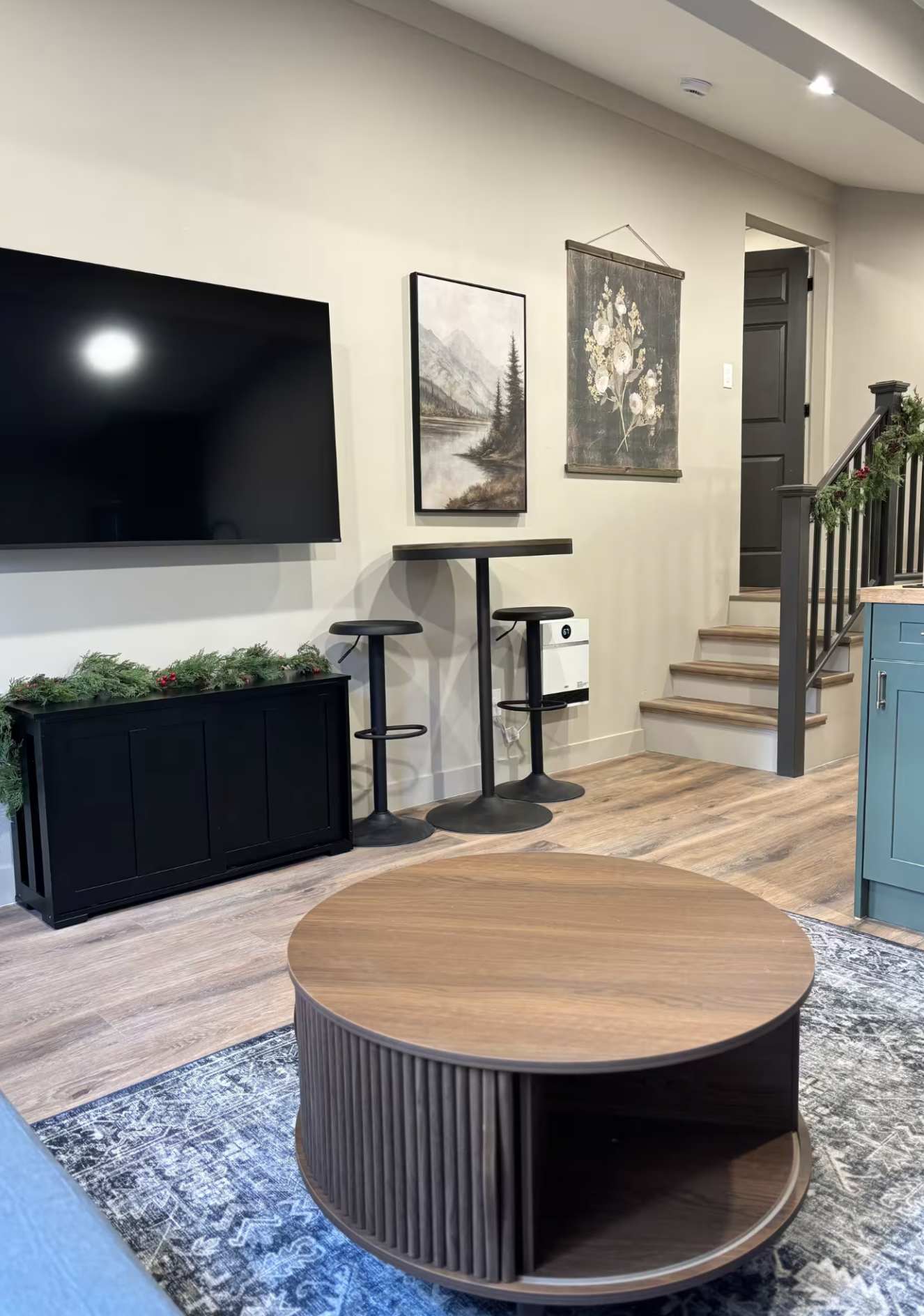 Stylish Kings Beach vacation rental with modern decor, wood accents, HDTV, and cozy seating area near stairs.