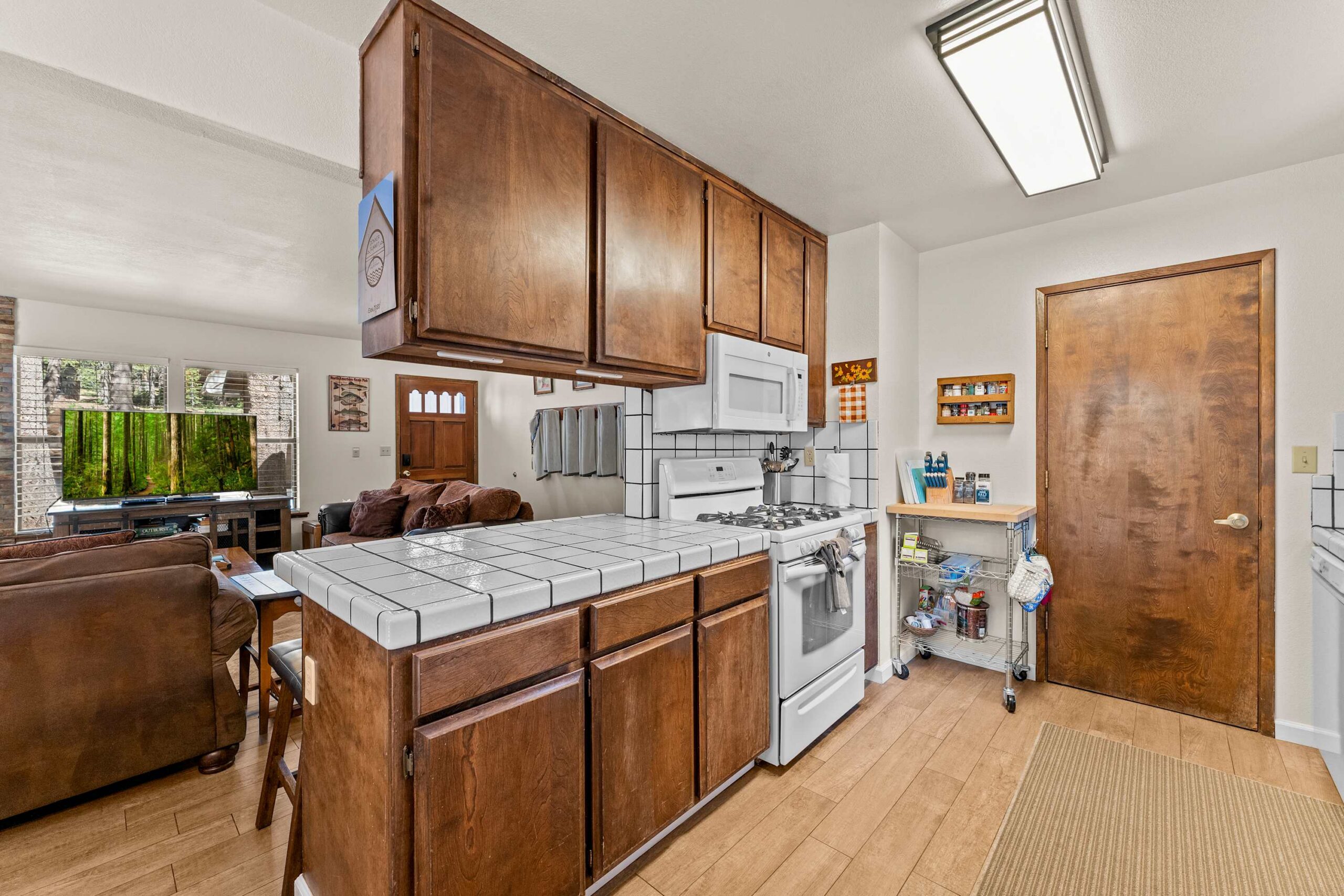 Kitchen and living room area in a cozy Truckee vacation rental, featuring wooden cabinets and a spacious layout.