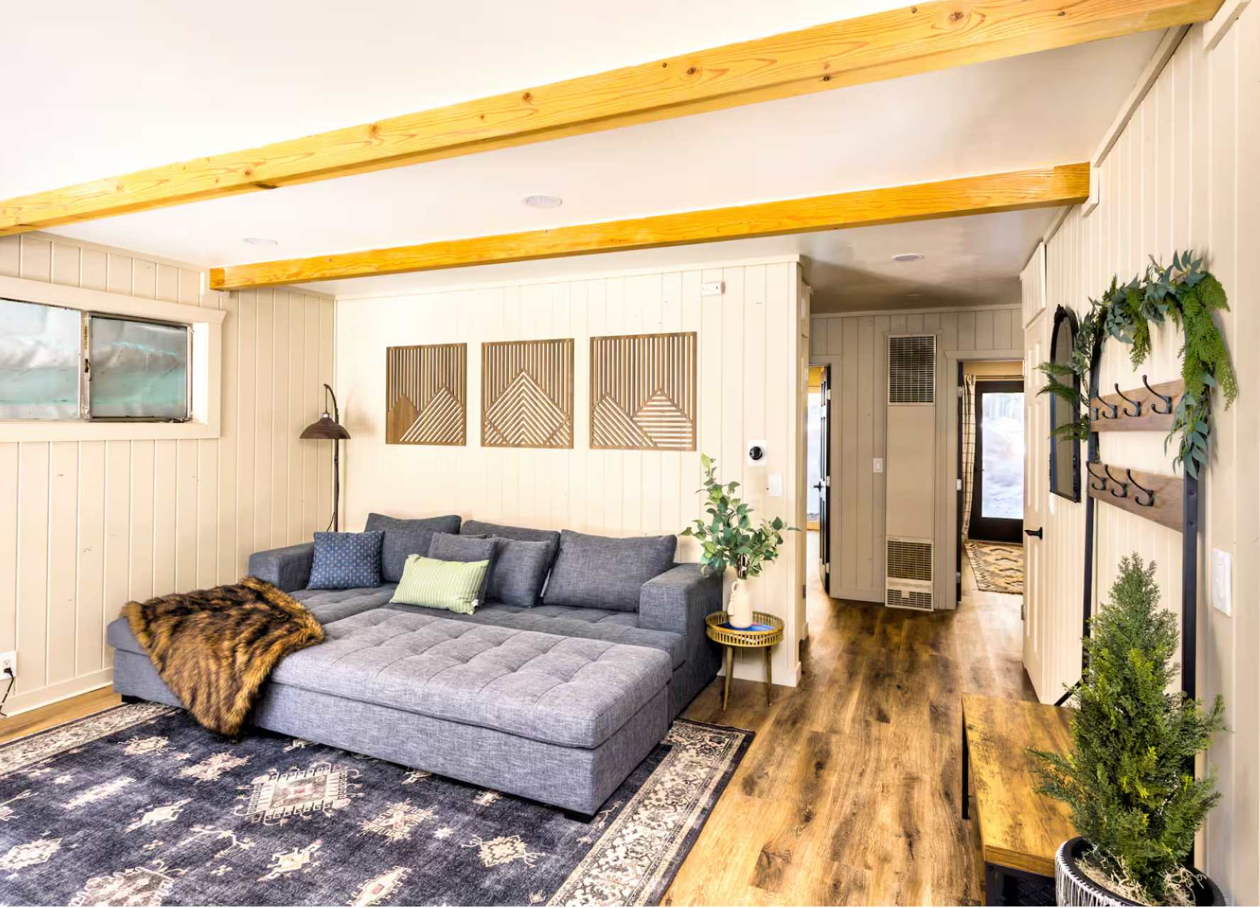 Modern living room in a Kings Beach vacation rental, featuring a comfy gray sofa, wood accents, and stylish decor.