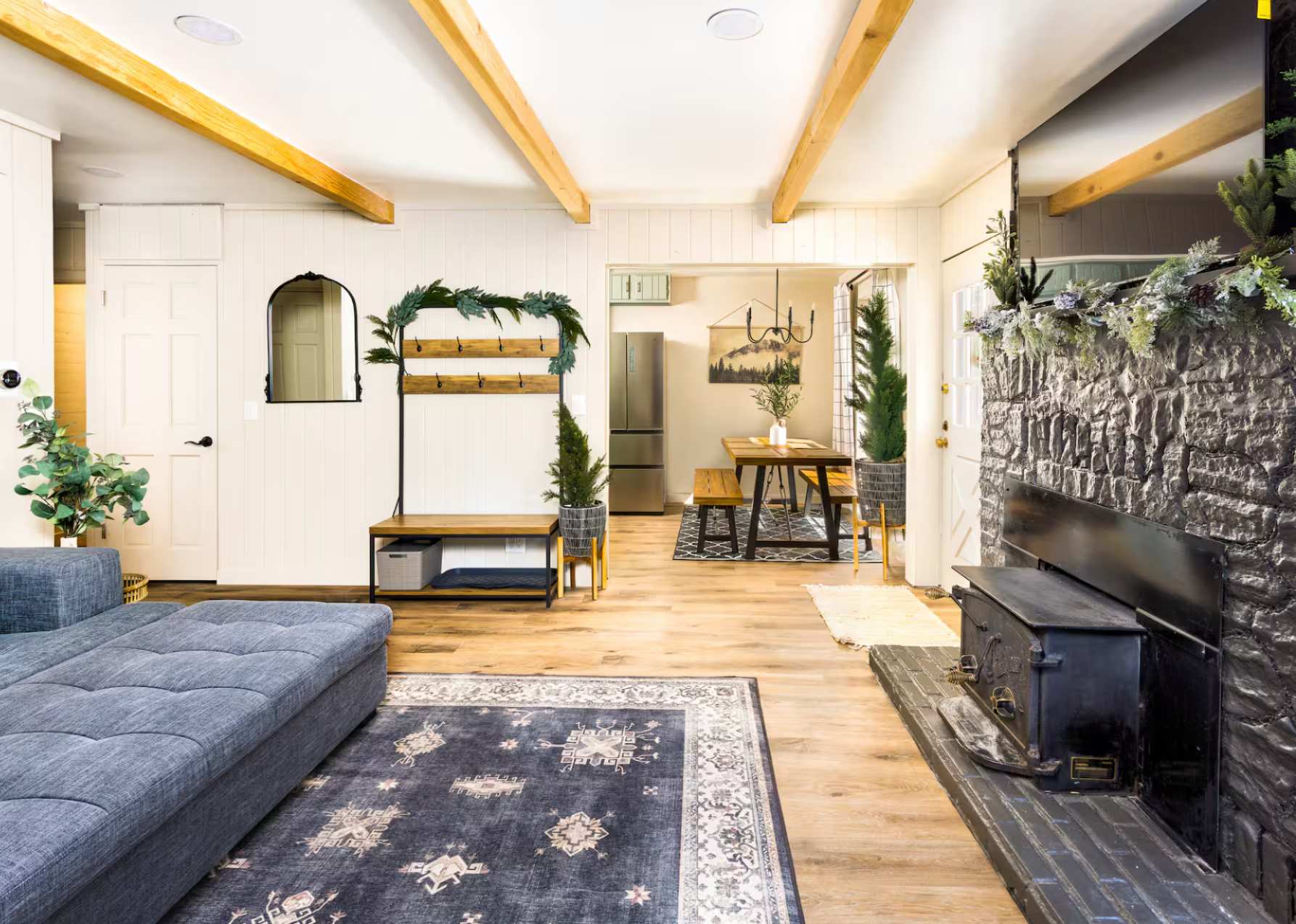 Cozy living room in a Kings Beach vacation rental, featuring a stone fireplace, rustic dining area, and modern decor.